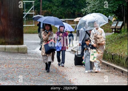 Les familles japonaises marchant par jour de pluie jusqu'au sanctuaire Meiji à Tokyo, au Japon Banque D'Images