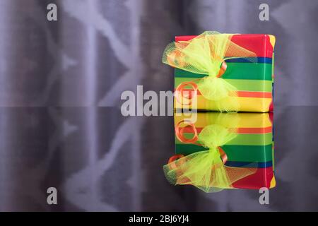 La boîte cadeau colorée et lumineuse est miroir reflété dans le tableau ci-dessous Banque D'Images