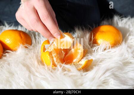 Femme peeling main mûre douce mandarine, gros plan Banque D'Images