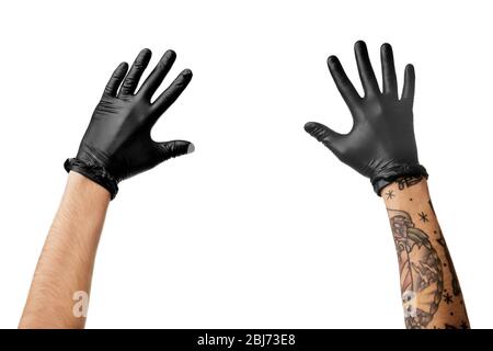 Les mains de l'homme avec tatouage dans des gants en latex noir Banque D'Images