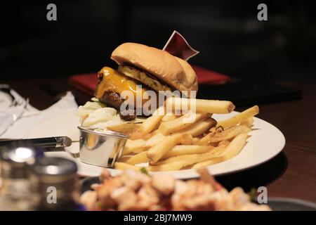 Hamburger classique avec frites et drapeau sur le dessus. Banque D'Images