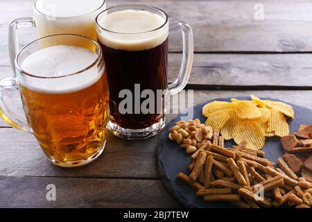 Divers types de bière et de collations sur table en bois Banque D'Images