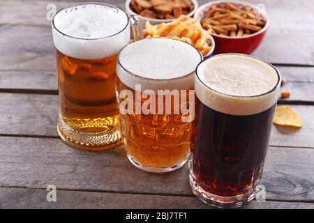 Divers types de bière et de collations sur table en bois Banque D'Images