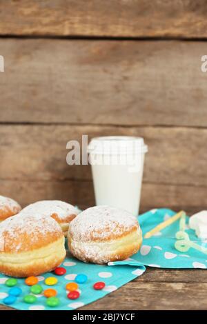 Délicieux beignets sucrés avec serviette bleue sur fond en bois Banque D'Images