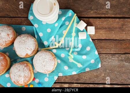 Délicieux beignets sucrés avec serviette bleue sur table en bois, vue sur le dessus Banque D'Images