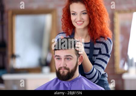 Coiffeur professionnel faisant de nouvelles cheveux sa belle cliente Banque D'Images