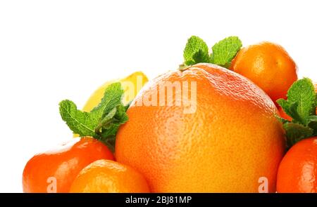 Un tas d'agrumes mélangés comprenant un pamplemousse, des oranges, des citrons, des clémentines, des mandarines avec des branches de menthe isolées sur un fond blanc, près de u Banque D'Images