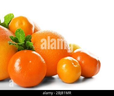 Un tas d'agrumes mélangés comprenant un pamplemousse, des oranges, des citrons, des clémentines, des mandarines avec des branches de menthe isolées sur un fond blanc, près de u Banque D'Images