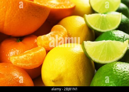 Agrumes mélangés colorés triés et alignés en rangées avec des tranches et des moitiés, gros plan Banque D'Images
