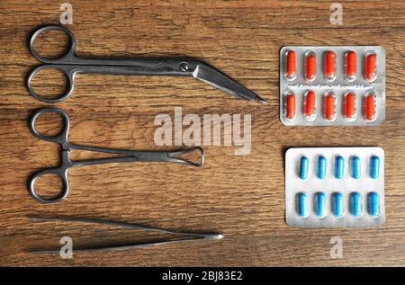 Table de médecin avec pilules et instruments chirurgicaux, vue de dessus Banque D'Images