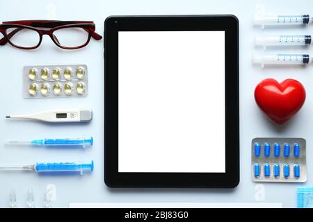 Table de médecin avec médicaments et comprimé, vue de dessus Banque D'Images