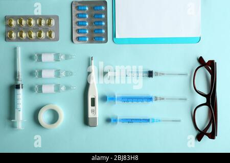 Table de médecin avec des articles médicaux et des pilules, vue de dessus Banque D'Images