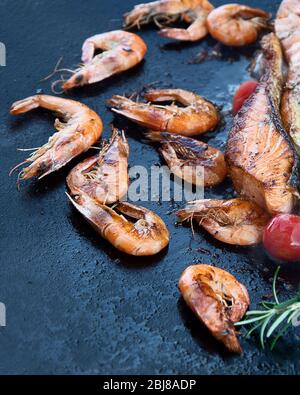 Gros plan de poissons et de crevettes grillés sur fond noir. Vue de dessus Banque D'Images