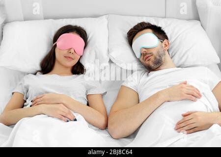 Jeune couple mignon dormant dans des masques pour les yeux. Banque D'Images