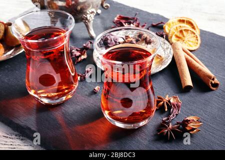 Thé hibiscus dans des tasses en verre et épices sur plaque d'ardoise Banque D'Images