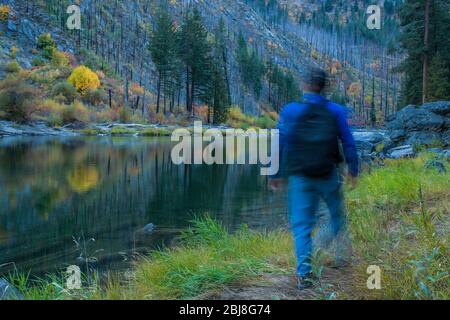 Un homme flou qui marche le long de la rivière Wenatchee dans Tumwater Canyon, État de Washington, États-Unis. Banque D'Images