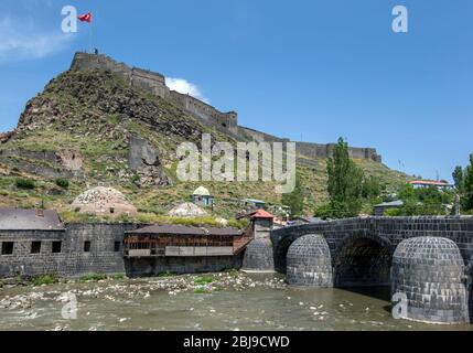 Vue montrant Taskopru (pont de pierre) construit au-dessus de la rivière Kars à Kars, Turquie en 1579 en utilisant des blocs de basalte de l'ashlar. Sur la colline au-dessus se trouve le château de Kars. Banque D'Images