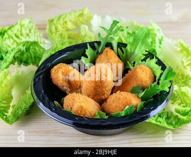 Assortiment de croquettes avec poisson et viande, laitue verte fraîche sur fond en bois. Concept de restauration rapide. Banque D'Images