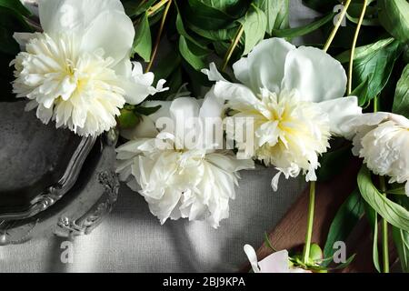 Composition avec de belles fleurs pivoines sur tissu blanc, vue sur le dessus Banque D'Images