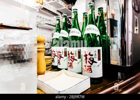 De nombreuses bouteilles de saké japonais au comptoir dans le restaurant japonais Izakaya. Banque D'Images