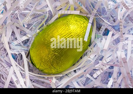 Feuille enveloppée d'oeuf de Pâques dans le nid de papier déchiqueté - concept d'oeuf de nid, sécurité Banque D'Images