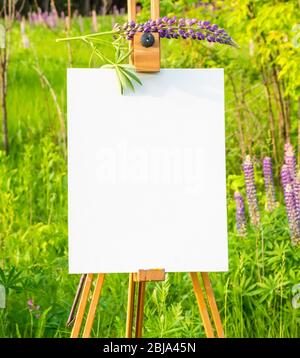 Chevalet en bois avec papier blanc sur fond vert Banque D'Images