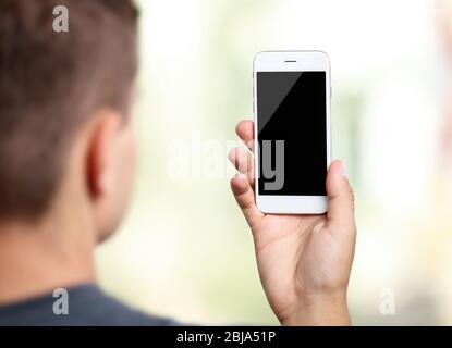 Jeune homme avec gadget sur fond flou Banque D'Images