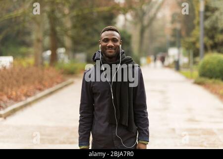 Portrait de Young Black Man Smiling sur Park Road Banque D'Images