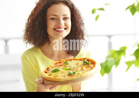 Belle jeune femme avec une pizza savoureuse Banque D'Images