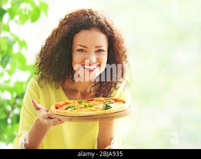 Belle jeune femme avec une pizza savoureuse Banque D'Images