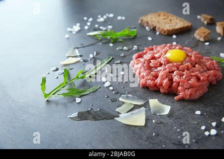 Steak au tartare avec ingrédients sur fond gris Banque D'Images