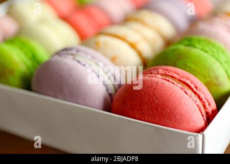 Différentes macarons colorés dans la boîte, gros plan Banque D'Images