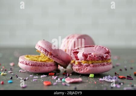 Macarons roses cassés savoureux sur table grise Banque D'Images