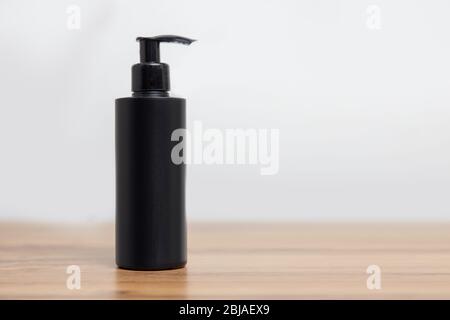 Maquette de bouteille noire pour shampooing cosmétique sur fond blanc simple Banque D'Images