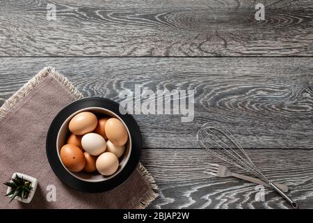 Les fermiers frais commercialisent des œufs sur une table de cuisine avec des ustensiles Banque D'Images