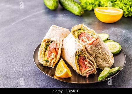 Sandwich emballé avec saumon, laitue, concombre et fromage à la crème, point de mire sélectif. Banque D'Images