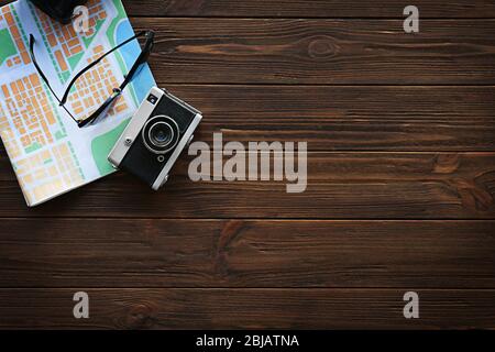 Appareil photo vintage avec carte et lunettes de soleil sur fond en bois Banque D'Images