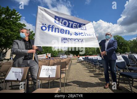 Mayence, Allemagne. 29 avril 2020. Les participants à la démonstration demandent l'ouverture de l'hôtel sur une affiche et se tiennent entre des chaises vides. L'industrie hôtelière et du restaurant attire l'attention sur la situation résultant de la pandémie avec des chaises vides sur Ernst-Ludwig-Platz. Crédit: Andreas Arnold/dpa/Alay Live News Banque D'Images