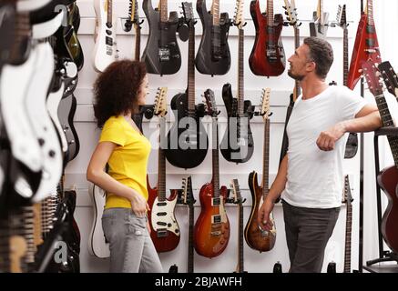 Homme et femme dans la boutique de musique Banque D'Images