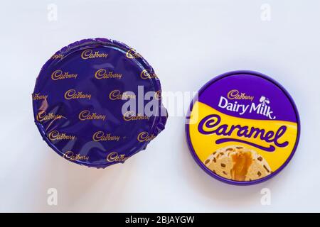 Cadbury lait laitier caramel crème glacée et morceaux Cadbury avec un coeur velouté de caramel lisse dans la cuve avec couvercle retiré isolé sur fond blanc Banque D'Images