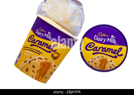 Cadbury lait laitier caramel crème glacée et morceaux Cadbury avec un coeur velouté de caramel lisse dans la cuve avec couvercle retiré sur fond blanc Banque D'Images