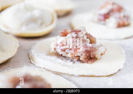 Le processus de fabrication de boulettes maison. Viande hachée sur la pâte, le processus de fabrication de boulettes maison. Cuisine russe. Banque D'Images