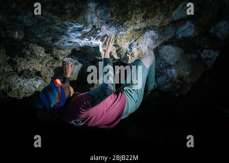 L'homme fait un bloc dans la grotte de Twardowski. Bourage dans le rock. Grotte de Twardowski Banque D'Images