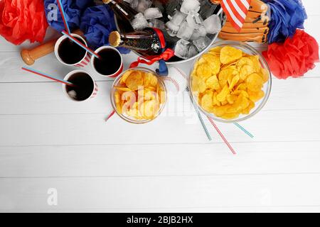 Seau avec bouteilles de bière, chips et boule sur fond blanc en bois Banque D'Images