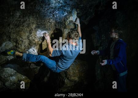 L'homme fait un bloc dans la grotte de Twardowski. Bourage dans le rock. Grotte de Twardowski Banque D'Images