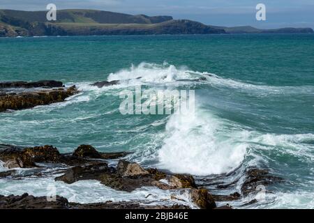 Vagues écrasantes aux Rocks dans la baie de Porpoise en Nouvelle-Zélande lors d'une journée de Stormy, Waikawa, Nouvelle-Zélande. Banque D'Images