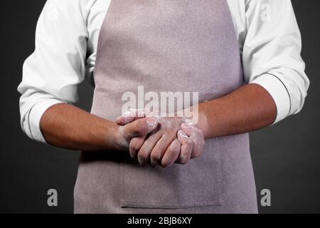 Un jeune chef cuisinier cuisiné avec des mains sales, se ferme Banque D'Images