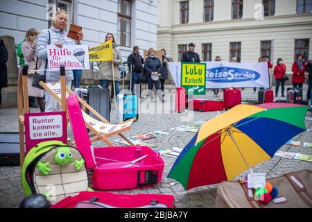 Schwerin, Allemagne. 29 avril 2020. Avec des valises vides et des chaises longues, les propriétaires et les employés des agences de voyage se tiennent devant la chancellerie d'État lors d'une manifestation. Compte tenu des faibles taux d'infection dans la région de Mecklembourg-Poméranie occidentale, les experts du voyage réclament une normalisation de la crise de la couronne. Jusqu'à 50 représentants des voyagistes utilisent l'action pour attirer l'attention sur leur situation économique difficile. D'autres participants ne sont pas autorisés en raison des règles de distance Corona actuelles. Crédit: Jens Büttner/dpa-Zentralbild/dpa/Alay Live News Banque D'Images