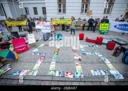 Schwerin, Allemagne. 29 avril 2020. Avec les catalogues de voyages, les propriétaires et les employés des agences de voyages ont utilisé le mot « se » pour protester devant la Chancellerie d'État. Compte tenu des faibles taux d'infection dans la région de Mecklembourg-Poméranie occidentale, les experts en voyages réclament une normalisation dans la crise de Corona. Jusqu'à 50 représentants des voyagistes utilisent l'action pour attirer l'attention sur leur situation économique difficile. D'autres participants ne sont pas autorisés en raison des règles de distance Corona actuelles. Crédit: Jens Büttner/dpa-Zentralbild/dpa/Alay Live News Banque D'Images