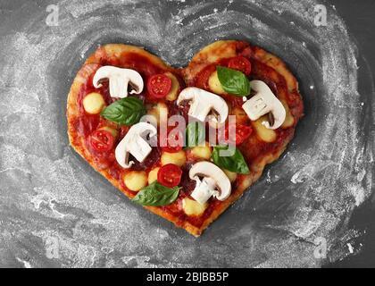 Pizza savoureuse en forme de coeur sur la table Banque D'Images